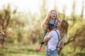 Young mother with adorable daughter in park with blossom tree