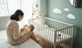 Young mother playing with baby boy on bed together. Royalty Free Stock Photo