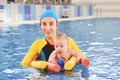 Young mother and baby son are in pool teaches swim