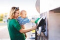 Young mother with baby boy at the petrol station. Royalty Free Stock Photo