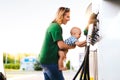 Young mother with baby boy at the petrol station. Royalty Free Stock Photo