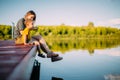 Young mother and baby boy sitting on dock launch soap bubbles. Summer photography for blog or ad about family and travel