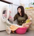 Young mother with baby doing laundry Royalty Free Stock Photo