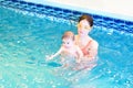 Young mother and baby playing in swimming pool Royalty Free Stock Photo