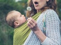 Mother with baby blowing dandelion Royalty Free Stock Photo
