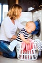 Young mother with a baby boy doing housework. Royalty Free Stock Photo