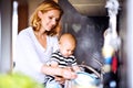 Young mother with a baby boy doing housework. Royalty Free Stock Photo