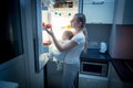 Young mother and baby son looking inside the fridge for something to eat Royalty Free Stock Photo