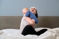 Young mother and baby together at home sitting in bed Royalty Free Stock Photo