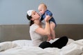 Young mother and baby together at home sitting in bed Royalty Free Stock Photo