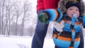 Young mother with a beautiful baby are walking in a winter park in snowy weather. Happy family Royalty Free Stock Photo