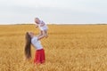Young mother with beautiful long hair holding cute baby. Mom and child playing in wheat field Royalty Free Stock Photo