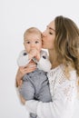 A young mother with blonde hair kisses her young son and holds him in her arms Royalty Free Stock Photo