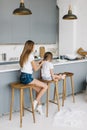 Young mother braids her daughter`s hair