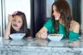 Young mother, breakfast portrait and child and happy girl or young people eating cereal, morning food or meal. Home Royalty Free Stock Photo