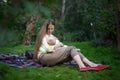 Young mother breast feeding her baby on nature background. Breast-feeding. Motherhood and care concept Royalty Free Stock Photo
