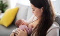 Young mother breastfeeding her newborn baby girl indoors at home, maternity leave. Royalty Free Stock Photo