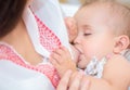 Young mother breastfeeds her baby.