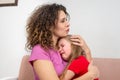 A young mother calms her daughter. The girl is crying and her mother hugged her with love