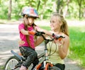 Young mother calms the sad daughter who did not get to ride a bike Royalty Free Stock Photo