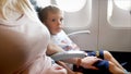 Young mother caressing and calming her little son before first flight in airplane Royalty Free Stock Photo