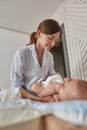 Young mother changes clothes on her baby Royalty Free Stock Photo