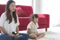 Young mother and child daughter doing yoga exercise sit on floor at home.