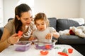 Young mother with child playing kinetic sand. Happy bonding time together. Creativity development