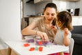 Young mother with child playing kinetic sand. Happy bonding time together. Creativity development