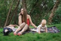 Young mother with child sitting on picnic blanket and talking on phone. Business woman with baby Royalty Free Stock Photo