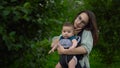 A young mother with a child walks and speaks on the phone in the park. A woman with glasses is in a hurry and clutched Royalty Free Stock Photo