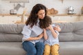 Young mother comfort crying son. Disturbed mom hug small upset preschool boy sitting in living room Royalty Free Stock Photo