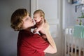 Young mother with crying newborn baby at home. Baby cry during colic