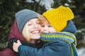 Young mother with cute child at winter snowy park. Winter family holidays. Close up portrait. Royalty Free Stock Photo