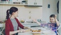 Young mother and cute daughter cooking together talking in the kitchen on weekend. Little girl clapping hands with flour Royalty Free Stock Photo