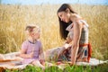 Young mother with cute daughter at wheat field Royalty Free Stock Photo