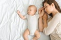 Young mother and cute little baby co-sleeping together in bed. Royalty Free Stock Photo