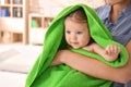 Young mother with cute little baby wrapped in soft towel at home Royalty Free Stock Photo