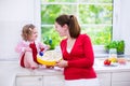 Young mother and daughter baking a pie together Royalty Free Stock Photo