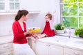 Young mother and daughter baking a pie together Royalty Free Stock Photo