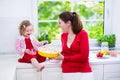 Young mother and daughter baking a pie together Royalty Free Stock Photo