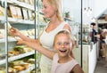 Mother with daughter buying chilled foods in supermarket Royalty Free Stock Photo