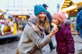 Young mother and daughter eating white chocolate covered fruits on skewer on traditional German Christmas market Royalty Free Stock Photo