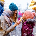 Young mother and daughter eating white chocolate covered fruits on skewer on traditional German Christmas market. Happy Royalty Free Stock Photo