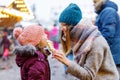 Young mother and daughter eating white chocolate covered fruits on skewer on traditional German Christmas market Royalty Free Stock Photo