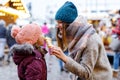 Young mother and daughter eating white chocolate covered fruits on skewer on traditional German Christmas market Royalty Free Stock Photo