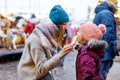 Young mother and daughter eating white chocolate covered fruits on skewer on traditional German Christmas market. Happy Royalty Free Stock Photo