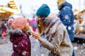 Young mother and daughter eating white chocolate covered fruits on skewer on traditional German Christmas market. Happy Royalty Free Stock Photo