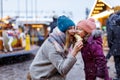 Young mother and daughter eating white chocolate covered fruits on skewer on traditional German Christmas market Royalty Free Stock Photo