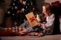 young mother and daughter open Christmas Lighting Present Gift Box front of Xmas Tree. Happy Mom with kid girl in Magic Royalty Free Stock Photo